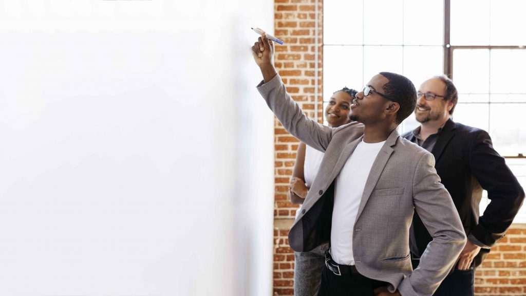 man writing on white board